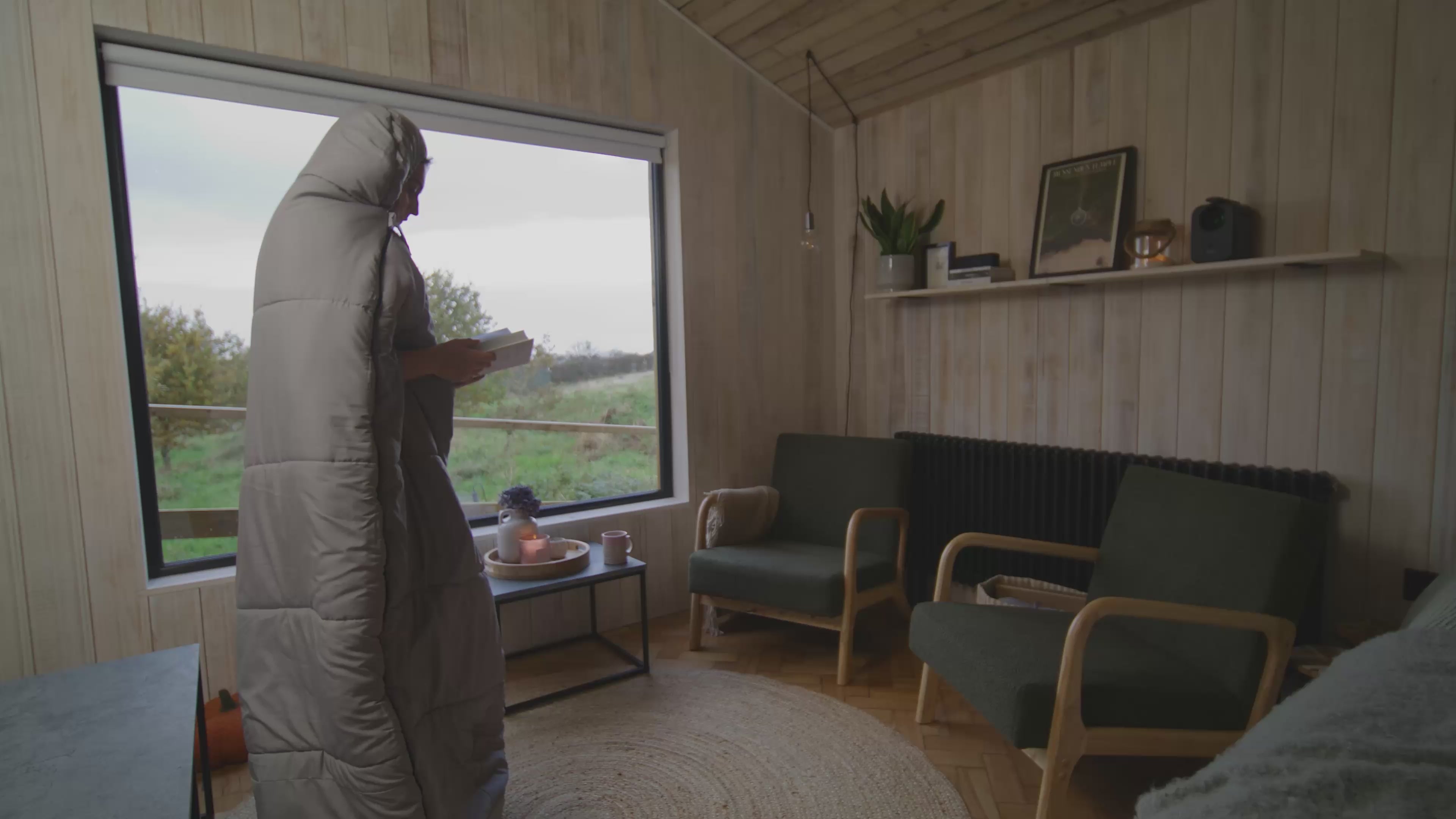 Overview video of person keeping warm while relaxing, working, and sleeping in a wearable sleeping bag called the 'SnoozePod'