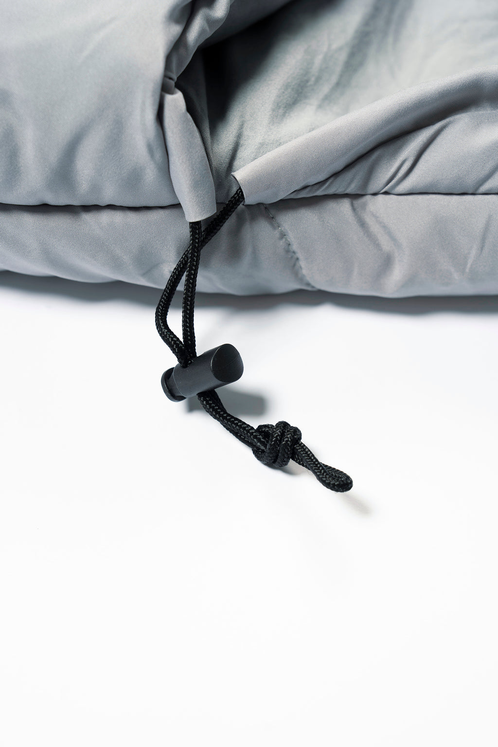 Close-up of a grey SnoozePod's hood drawstring on a white background