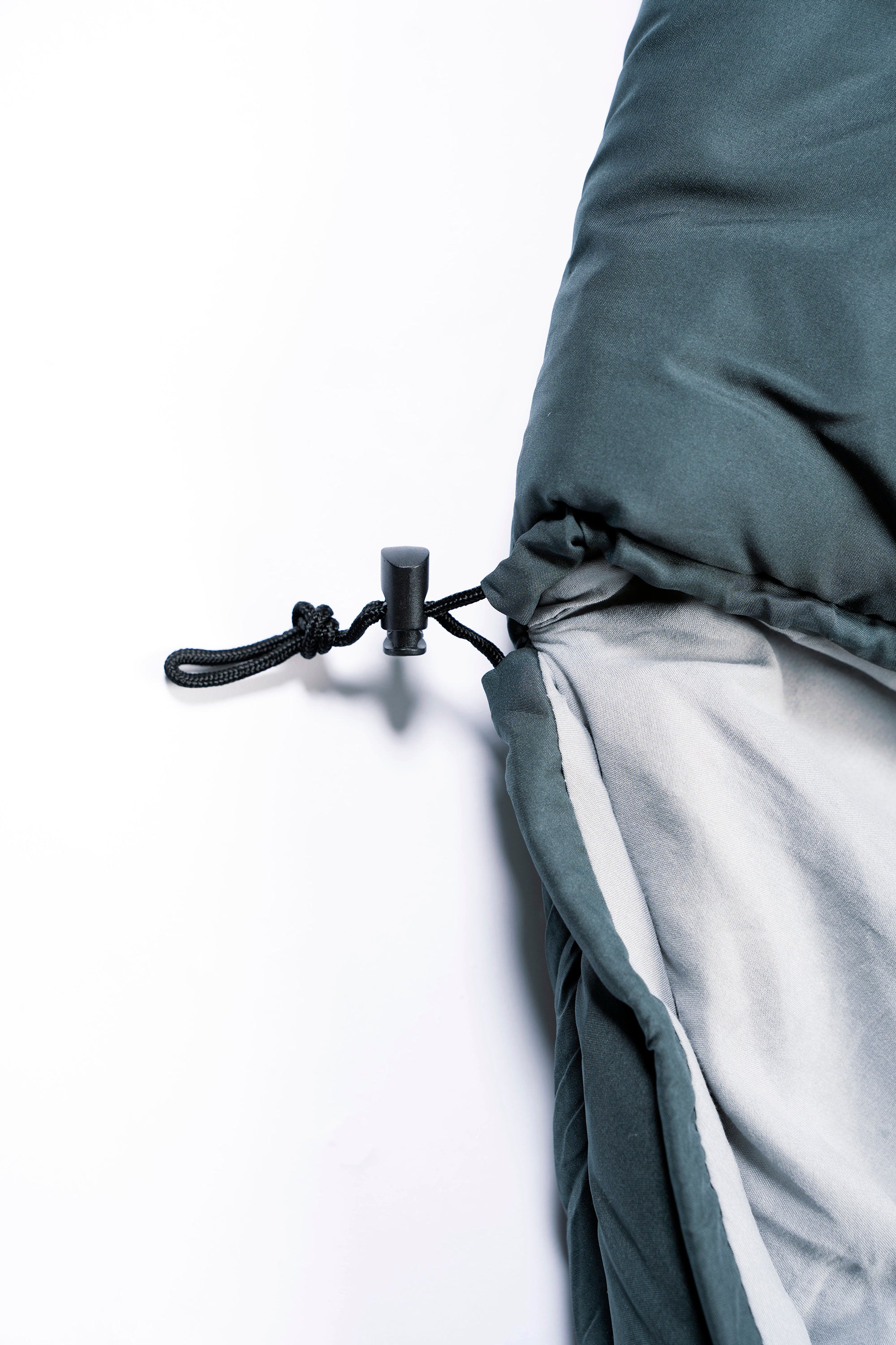 Close-up of a green SnoozePod's hood drawstring on a white background